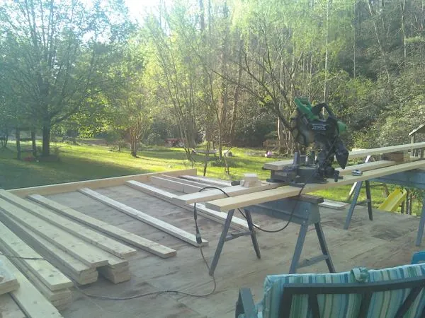 Miter saw and framing lumber on a deck under construction in Clarkrange